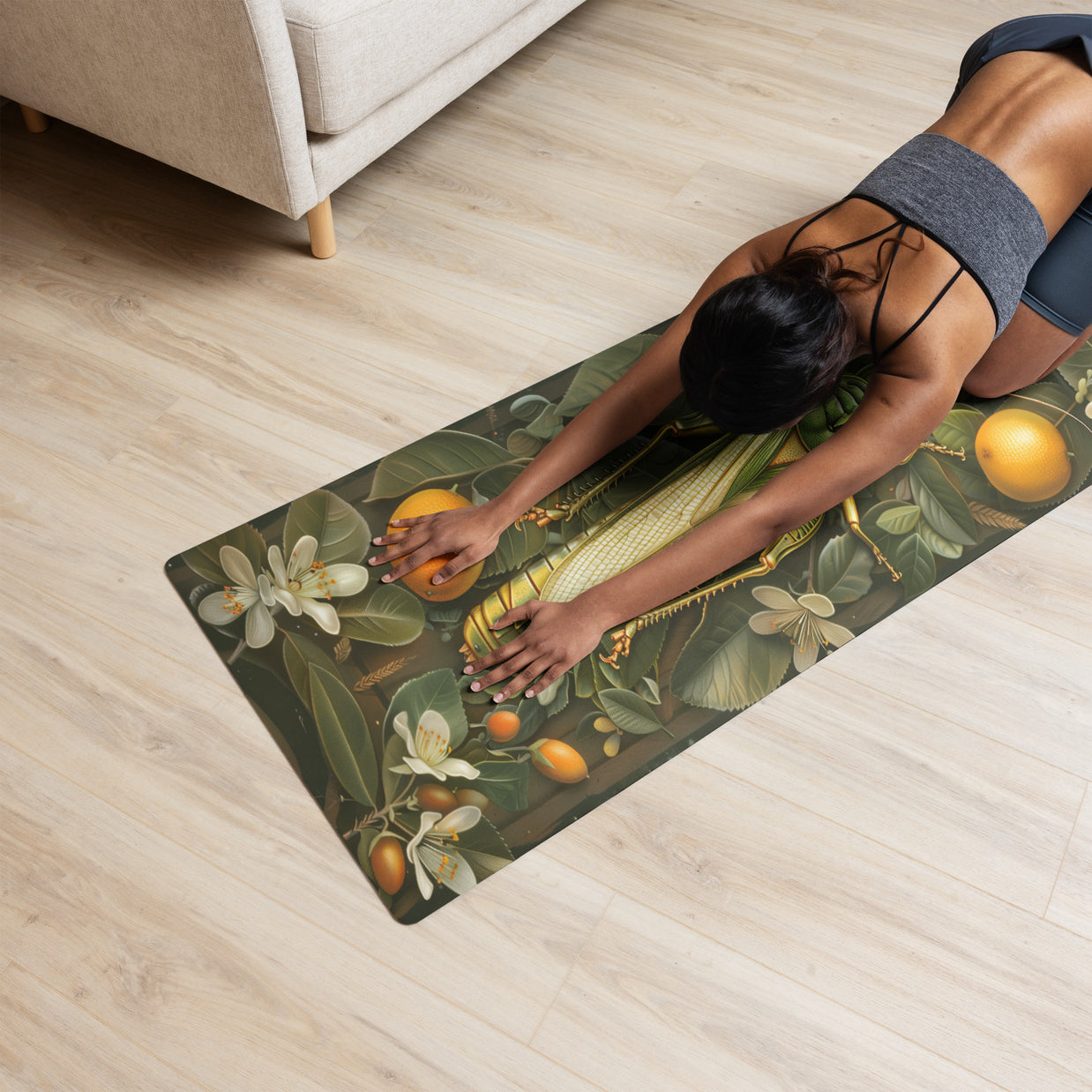 Yoga mat with botanical print featuring citrus fruits, white flowers, and green leaves on olive background on wood floor