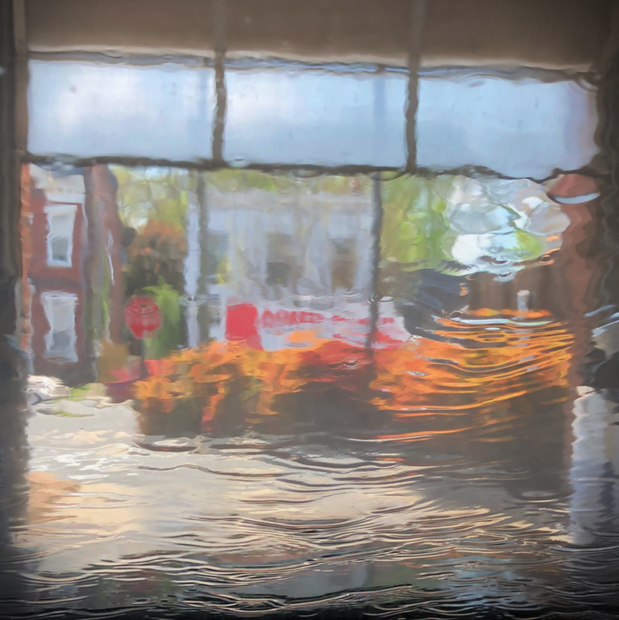 A metal print featuring a reflective surface with an impressionist view of a carwash window.