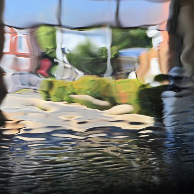 A metal print featuring a blurred image of a car wash with reflections and colors distorted in an impressionistic style.